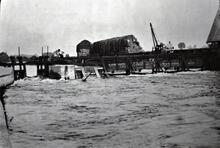 Weir and flash lock, by crane and large haystacks on bank