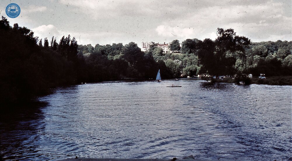 River with stately  home on hill.