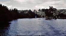 River with stately  home on hill.