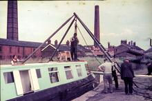Middlewich Lock 73,. Peter Froud's hotel boat "SATURN" being lifted on the cill after its encounter with the top gate. 1965