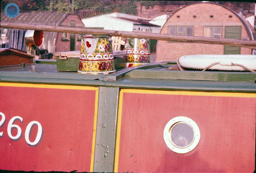 Coventry Canal. Painted water cans on cabin top of Linda at Coventry Basin