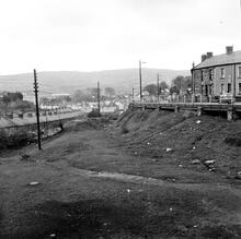 Penydarren Tramroad.  Penydarren, Merthyr Tydfil. A view looking west at S0 055070 showing the line running below the road. May 1964 (1)