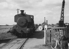 Near Grantham. 0-6-0 'Stainby' passing over the level crossing on the Sewstern - Gunby road, with 1 wagon. 12 April 1963.