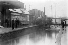 Stratford Low Level Station 1903 (DWW2 @ 3m 70ch). Flooded tracks being cleared by a pump driven by a portable steam engine. (Ref: 031347))
