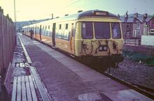Glossop station (GDW @ 0m 01ch). EMU 303060 in orange livery. 14 June 1985
