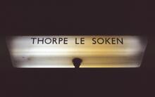 Thorpe-le-Soken station  (COC @ 65m 07ch). Illuminated platform sign / lamp. 11 April 1987 (Ref: 221487)