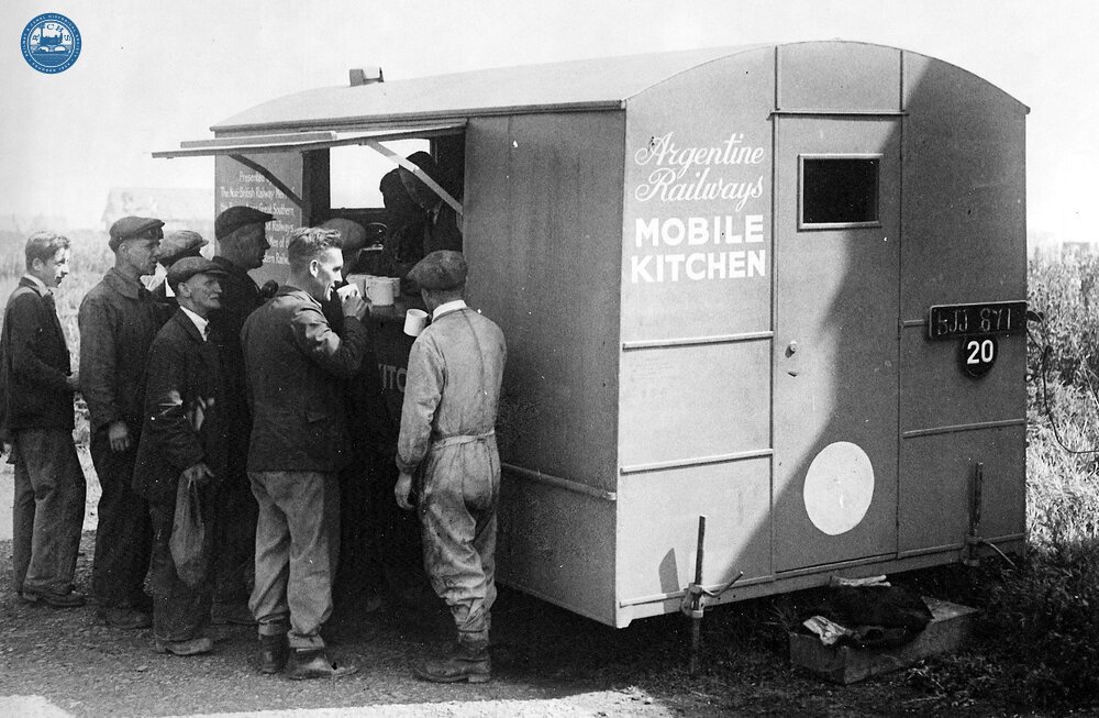 Men working on clearing the bomb damaged Southcoates Lane Bridge in Hull obtaining refreshment from a Mobile Kitchen presented to Britain's railways by the Argentine railways. July 1943. (Ref: 030827)