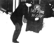 LMS Station Porter writing public notice that no trains are running - because of deep snow. (Ref: 031345)