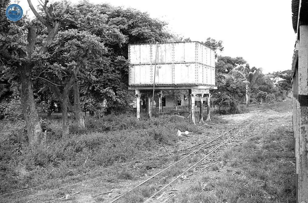 017833E Water tank. Taken on the Free train at a stop between Sigatoka and Nandi. 3 November 1973
