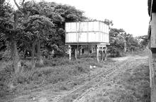 017833E Water tank. Taken on the Free train at a stop between Sigatoka and Nandi. 3 November 1973